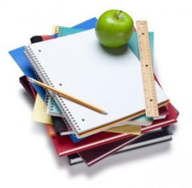 An image of a stack of textbooks with a ruler, pencil and apple sitting on top.