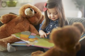 An image of a little girl reading a book.