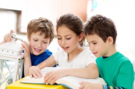 An image of three kids reading together.