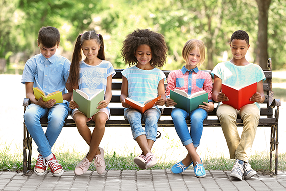elementary kids reading on bench